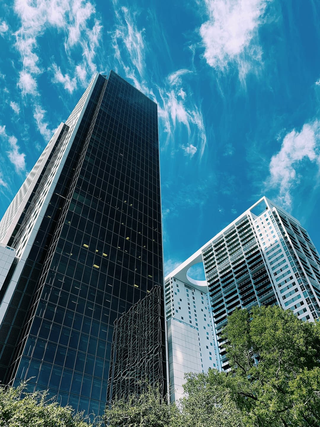 Black-glass commercial towers under a blue sky.
