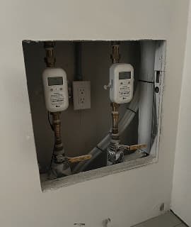 Eddy meters installed in a wall recess on a tenant floor.