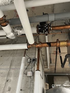 Eddy metering on overhead copper water mains in a mechanical area