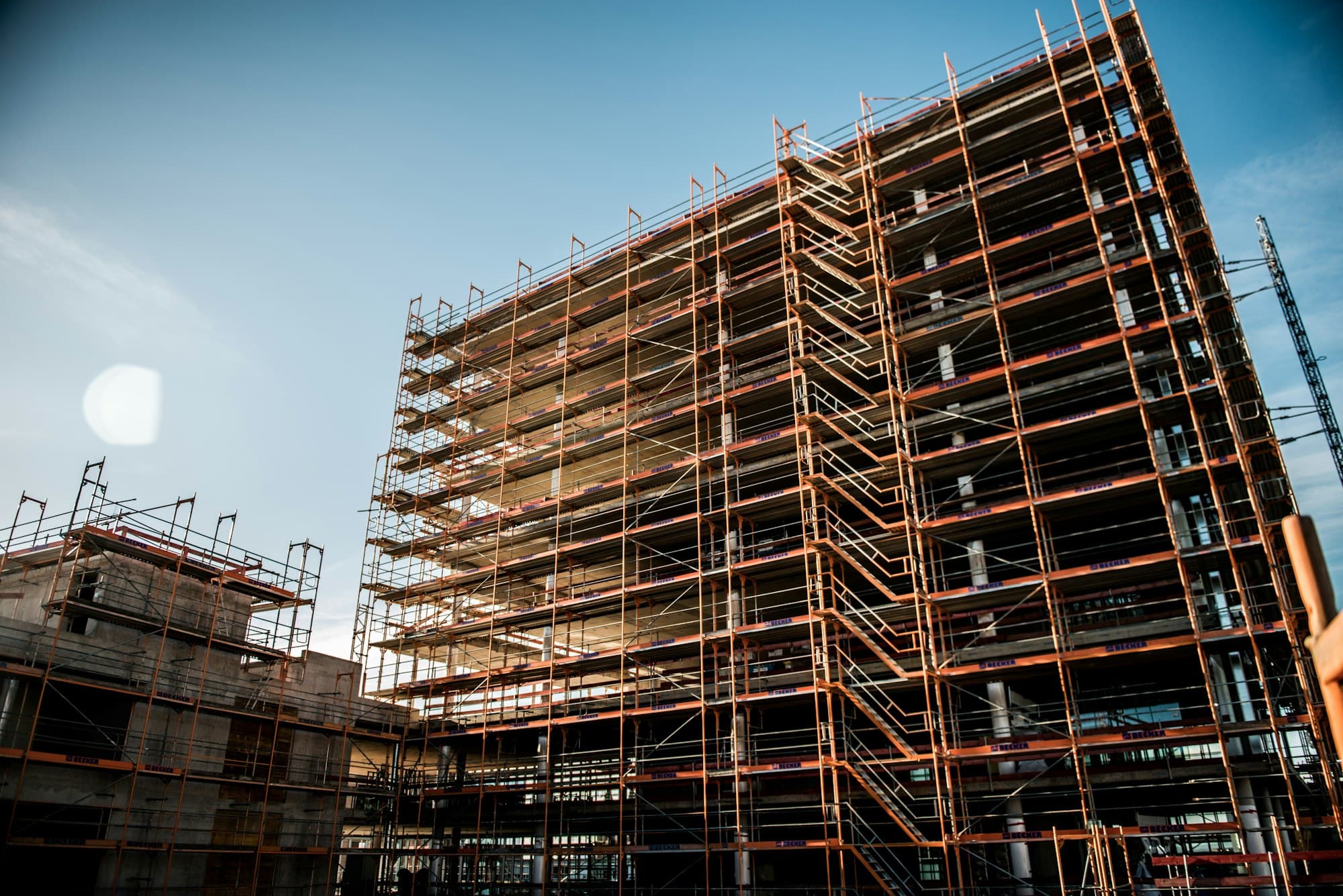 Concrete building under construction wrapped in scaffolding.