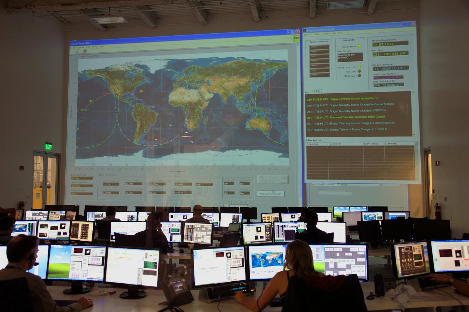 Control-room monitors showing live data dashboards.