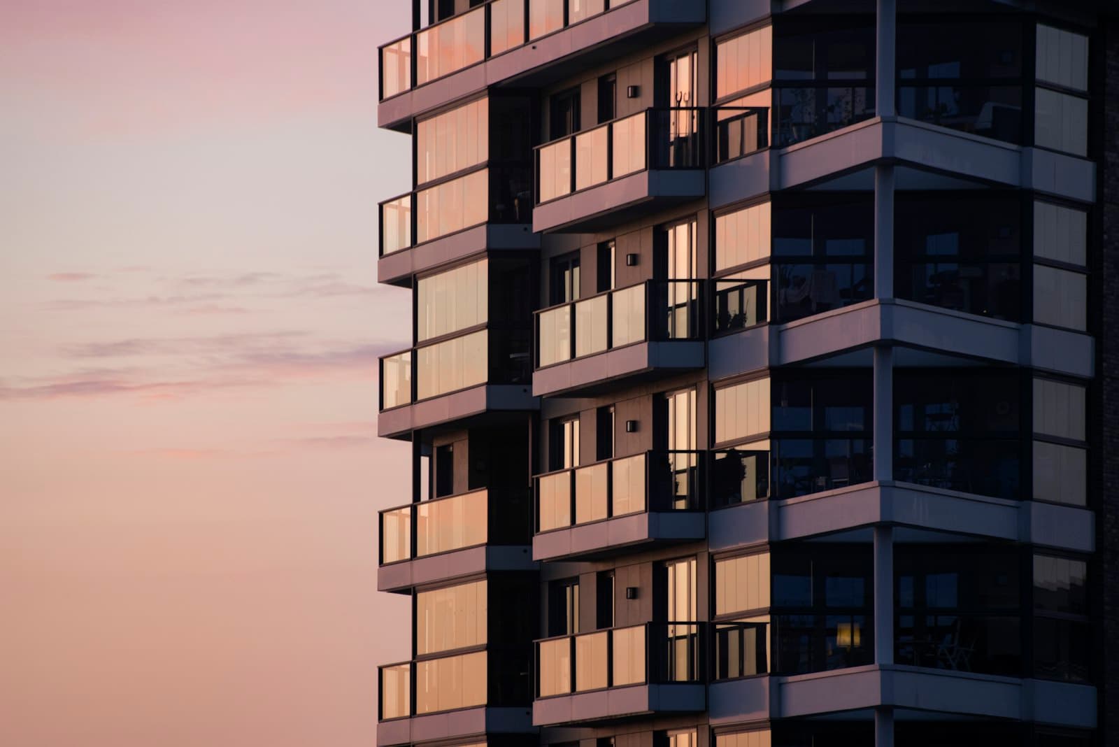 Modern residential building glowing in soft sunset light.